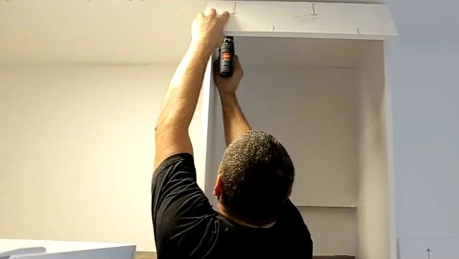 Handyman installing custom shelving in a Dayton area home